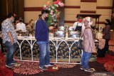 Tamu undangan menjaga jarak pada simulasi resepsi pernikahan di masa normal baru pengantin Fahreza Ahmad dan Mafella Firdausi di Fave Hotel Sidoarjo, Jawa Timur, Senin (13/7/2020). Kegiatan simulasi resepsi pernikahan tersebut bertujuan untuk mengedukasi masyarakat tentang pentingnya penerapan protokol kesehatan dalam acara pernikahan guna mencegah penyebaran dan penularan COVID-19 di masa normal baru. Antara Jatim/Umarul Faruq/zk