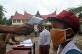 Guru memeriksa suhu tubuh murid saat hari pertana masuk sekolah di SDN 11 Marunggi, Pariaman, Sumatera Barat, Senin (13/7/2020). Kota Pariaman bersama Kabupaten Pesisir Selatan, Kota Sawahlunto dan Kabupaten Pasaman Barat merupakan empat daerah di zona hijau di Sumatera Barat yang sudah memulai aktivitas belajar-mengajar di sekolah dengan pola tatap muka langsung dan menerapkan protokol kesehatan COVID-19. ANTARA FOTO/Iggoy el Fitra/wsj.