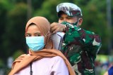 Seorang personel TNI AD memasangkan masker kepada warga yang terjaring razia kepatuhan penggunaan masker di Taman Digulis, Pontianak, Kalimantan Barat, Minggu (12/7/2020). Dinas Kesehatan Kalbar bersama TNI dan Satpol PP gencar melakukan sosialisasi protokol kesehatan dan tes usap atau swab test kepada warga yang terjaring razia kepatuhan penggunaan masker guna mempertahankan zero kasus positif COVID-19 di Kota Pontianak. ANTARA FOTO/Jessica Helena Wuysang/foc.