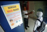 Petugas memeriksa suhu tubuh siswi sebelum masuk ke sekolah di SMAN 1 Slawi, Kabupaten Tegal, Jawa Tengah, Selasa (14/7/2020). Menurut pihak sekolah melalui surat edaran dari Dinas Pendidikan Jawa Tengah mulai 14 Juli hingga 15 Juli kegiatan Masa Pengenalan Lingkungan Sekolah (MPLS) siswa baru SMA/SMK dihentikan dan digantikan MPLS secara daring akibat masih tingginya penularan dan penyebaran COVID-19 di Jawa Tengah. ANTARA FOTO/Oky Lukmansyah/nym.