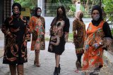 Sejumlah model mengenakan busana perpaduan batik dan tenun di rumah busana kawasan Candi, Sidoarjo, Jawa Timur, Rabu (15/7/2020). Peragaan busana dengan menerapkan protokol kesehatan tersebut bertujuan untuk adaptasi dengan tatanan normal baru dan inspirasi bagi industri kreatif di Indonesia di tengah pandemi COVID-19. Antara Jatim/Umarul Faruq/zk