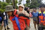 Tim SAR menggendong seorang korban banjir bandang saat dievakuasi di Desa Radda, Kabupaten Luwu Utara, Sulawesi Selatan, Selasa (14/7/2020). Akibat banjir bandang tersebut mengakibatkan 10 orang meninggal dunia dan ratusan rumah tertimbun lumpur. ANTARA FOTO/Hariandi Hafid/yu/hp.