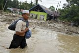 Warga berusaha menerobos banjir di Desa Radda, Kabupaten Luwu Utara, Sulawesi Selatan, Selasa (14/7/2020). Akibat banjir bandang tersebut mengakibatkan 10 orang meninggal dunia dan ratusan rumah tertimbun lumpur. ANTARA FOTO/Hariandi Hafid/yu/hp.