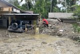Warga berusaha memeanjat kedalam rumahnya yang tenggelam lumpur akibat banjir bandang di Desa Radda, Kabupaten Luwu Utara, Sulawesi Selatan, Selasa (14/7/2020). Akibat banjir bandang tersebut mengakibatkan 10 orang meninggal dunia dan ratusan rumah tertimbun lumpur. ANTARA FOTO/Hariandi Hafid/yu/hp.