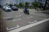 Pengendara sepeda dan motor berhenti di garis yang dibuat secara berjarak di perempatan Pemda Soreang, Kabupaten Bandung, Jawa Barat, Kamis (16/7/2020). Pembuatan jarak bagi pengendara sepeda motor tersebut ditujukan untuk mengantisipasi penyebaran COVID-19 di kawasan umum. ANTARA FOTO/Raisan Al Farisi/nz