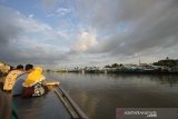 Warga menikmati pemandangan kampung biru saat wisata susur Sungai Martapura di Banjarmasin, Kalimantan Selatan, Jumat (17/7/2020). Wisata susur Sungai Martapura tersebut menawarkan suasana alam serta aktivitas warga di bantaran sungai saat akhir pekan banyak didominasi wiasatawan domestik maupun warga lokal untuk bersantai bersama keluarga serta kerabat. Foto Antaranews Kalsel/Bayu Pratama S.