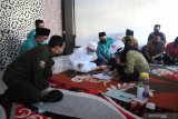 Bupati Sumenep KH A Busyro Karim (tengah) mengisi data diri saat  Pencocokan dan Penelitian (Coklit) serentak disaksikan Anggota KPU Jatim Miftahurrazaq (kiri) di Desa Braji, Sumenep, Jawa Timur, Sabtu (18/7/2020). Pelaksanaan Coklit di kabupaten tersebut berlangsung  sejak  tanggal 15 Juli hingga 13 Agustus, dengan jumlah hak pilih sekitar 886 ribu lebih yang tersebar di 2.500 TP dan 334 desa/keluragan seeta 27 kecamatan. Antara Jatim/Saiful Bahri/zk