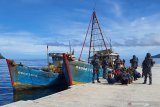 Perwira Pelaksana (Palaksa) KRI Yos Sudarso-353 Kapten Laut (P) Mahmud Ridho (tengah) berserta prajurit TNI AL awak KRI Yos Sudarso-353 mengiring para tahanan awak Kapal Ikan Asing (KIA) Vietnam yang berhasil diamankan di Pelabuhan Fasilitas labuh (Faslabuh) TNI AL di Selat Lampa Natuna, Kepulauan Riau, Sabtu (18/7/2020). KRI Yos Sudarso-353 berhasil menangkap kedua KIA tersebut di perairan Pulau Sekatung dan mengamankan 10 orang WNA beserta barang bukti ikan hasil tangkapannya. Antara Jatim/Ardi/ZK