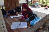 Seorang relawan membimbing murid SD belajar di pos keamanan lingkungan (poskamling) Desa Brumbun, Kecamatan Wungu, Kabupaten Madiun, Jawa Timur, Kamis (23/7/2020). Kegiatan tersebut dilakukan akibat keterbatasan sarana belajar secara daring, antara lain belum seluruh murid memiliki gawai serta minimnya jaringan internet. Antara Jatim/Siswowidodo/zk.