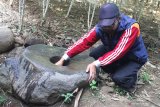 Warga membersihkan batu lumpang yang ditemukan di sekitar situs struktur batu bata kuno di areal perkebunan di Langlang, Singosari, Malang, Jawa Timur, Kamis (23/7/2020). Di sekitar situs tersebut juga ditemukan pecahan tembikar kuno sehingga memperkuat dugaan bahwa struktur batu bata kuno tersebut merupakan bangunan candi pada era sebelum kerajaan Singasari di abad ke-9 Masehi. Antara Jatim/Ari Bowo Sucipto/zk.