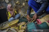 Warga menyelesaikan pembuatan kerajinan anyaman dari bambu di Kampung Pangaroan, Desa Cipanas, Tanjung Kerta, Kabupaten Sumedang, Jawa Barat, Sabtu (25/7/2020). Kampung Pangaroan yang terkenal sebagai sentra penghasil perkakas rumah tangga berbahan anyaman bambu sejak 1930-an tersebut saat ini tercatat sebanyak 50 kepala keluarga yang melanjutkan tradisi menganyam serta menjual hasil karya anyaman bambu dari harga Rp 3 ribu hingga Rp 200 ribu tergantung tingkat kerumitannya. ANTARA JABAR/Raisan Al Farisi/agr