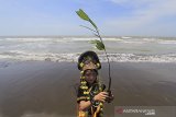 Seorang anak membawa bibit mangrove untuk ditanam di pesisir pantai Pabean udik, Indramayu, Jawa Barat, Minggu (26/7/2020). Aksi menanam mangrove dan pemasangan Alat Pemecah Ombak (APO) yang digagas Kelompok Rumah Berdikari tersebut dilakukan untuk memperingati Hari Mangrove Internasional. ANTARA JABAR/Dedhez Anggara/agr