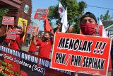 Puluhan buruh PT Sumber Graha Sejahtera (SGS) Jombang menggelar aksi unjuk rasa di Balai Latihan Kerja Kabupaten Jombang, Jawa Timur, Selasa (28/7/2020). Aksi demo buruh itu menuntut pembayaran kekurangan Tunjangan Hari Raya (THR), pemotongan upah sebesar 30 persen serta menolak pemutusan hubungan kerja sepihak tersebut tetap menjaga jarak fisik (physical distancing) sesuai dengan protokol kesehatan pencegahan COVID-19. Antara Jatim/Syaiful Arif/zk