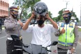 Polisil Lalulintas Polda Aceh mengenakan Face shield dan masker membagikan helm dan masker gratis kepada pengemudi sepeda motor saat Operasi Patuh Seulawah di Banda Aceh, Aceh, Rabu (29/7/2020). Operasi Patuh Seulawah berlangsung hingga tanggal 5 Agustus 2020 itu membagikan helm dan masker gratis untuk memberikan aspirasi kepada warga agar mematuhi keselamatan dan kelengkapan surat kendaraan serta mensosialisasikan penerapan protokol kesehatan guna mencegah penyebaran pandemi COVID-19. Antara Aceh/Ampelsa.