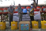 Direktur Utama PT Antang Gunung Meratus Doddy Imam Hidayat (dua kiri) menyerahkan bantuan alat sprayer elektrik disinfektan yang diterima Bupati Hulu Sungai Selatan Achmad Fikri (kanan) di Kantor Bupati Hulu Sungai Selatan, Kandangan, Kabupaten Hulu Sungai Selatan, Kalimantan Selatan, Kamis (30/7/2020). PT. Antang Gunung Meratus memberikan bantuan berupa sembako dan peralatan pencegahan penyebaran COVID-19 kepada masyarakat terdampak COVID-19 di Kabupaten Hulu Sungai Selatan. Foto Antaranews Kalsel/Bayu Pratama S.