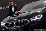 Model berpose di samping  BMW Seri 8 Gran Coupe saat peluncuran mobil tersebut di BMW Astra Surabaya, Jawa Timur, Kamis (30/7/2020). The 8 Grand Coupe merupakan satu-satunya kendaraan di segmennya yang dikembangkan langsung dari sport car dua pintu dan menjadi mobil paling mewah dalam portofolio produk BMW. Antara Jatim/Zabur Karuru