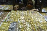 Pramuniaga menata perhiasan emas di sebuah gerai emas di Malang, Jawa Timur, Kamis (30/7/2020). Pengusaha perhiasan setempat mengaku sejak sepekan terakhir masyarakat yang menjual perhiasan emas meningkat dari 100 orang menjadi 175 orang per minggu atau naik 75 persen seiring melonjaknya harga emas perhiasan dari  Rp650 ribu menjadi 750 ribu rupiah per gram dengan kadar 70 persen. Antara Jatim/Ari Bowo Sucipto/zk