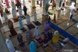 Umat muslim melakukan shalat Idul Adha 1441 Hijriah di Masjid Agung Baitul Hakim Kota Madiun, Jawa Timur, Jumat (31/7/2020). Shalat Idul Adha di masjid tersebut dilaksanakan dengan tetap menerapkan protokol kesehatan pencegahan COVID-19 seperti pemeriksaan suhu tubuh, memakai masker dan menjaga jarak. Antara Jatim/Siswowidodo/zk.