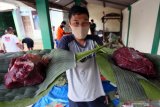 Warga menunjukkan potongan daging kurban yang siap dikemas emnggunakan daun pisang dan daun pohon jati di Blitar, Jawa Timur, Minggu (31/7/2020). Warga didaerah itu memanfaatkan dedaunan untuk membungkus daging kurban dengan tujuan untuk mendukung program pemerintah dalam meminimalisir penggunaan plastik (diet plastik). Antara Jatim/Irfan Anshori/zk.