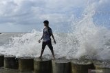 Pengunjung menikmati sensasi deburan ombak di Pantai Wisata Jumiang, Pamekasan, Jawa Timur, Minggu (2/8/2020). Kendati cuaca laut di awal Bulan Agustus ini, sedang tidak bersahabat, namun justru semakin menambah daya tarik pengunjung untuk menikmati sensasi mandi diantara deburan ombak besar. Antara Jatim/Saiful Bahri/zk