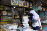 Pembeli memilih buku di sentra buku bekas di belakang Johar Plaza, Jember, Jawa Timur, Selasa (4/8/2020). Penerapan kegiatan belajar mengajar secara daring di masa pandemi COVID-19 berdampak menurunnya penjualan buku pelajaran bekas meskipun saat ini memasuki tahun ajaran baru sekolah. Antara Jatim/Seno/zk