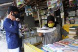 Penjual (kanan), mencari buku di sentra buku bekas di belakang Johar Plaza, Jember, Jawa Timur, Selasa (4/8/2020). Penerapan kegiatan belajar mengajar secara daring di masa pandemi COVID-19 berdampak menurunnya penjualan buku pelajaran bekas meskipun saat ini memasuki tahun ajaran baru sekolah. Antara Jatim/Seno/zk