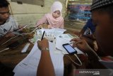 Sejumlah siswa mengikuti proses belajar mengajar dalam jaringan (daring) di bekas posko COVID-19 di tepi jalan untuk mendapatkan sinyal jaringan internet di Desa Madang, Kabupaten Hulu Sungai Selatan, Kalimantan Selatan, Selasa (4/8/2020). Siswa sekolah di pelosok Kalimantan Selatan masih kesulitan untuk mengikuti proses belajar mengajar daring selama masa pandemi COVID-19 akibat sulitnya akses internet di daerah itu. Foto Antaranews Kalsel/Bayu Pratama S.