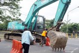 Petugas memarkir alat berat di ujung jembatan untuk menutup akses jalan nasional Tulungagung-Trenggalek di titik ruas jembatan Lembupeteng, Tulungagung, Jawa Timur, Selasa (4/8/2020). Penutupan sementara diberlakukan selama 60 hari ke depan untuk kepentingan rehabilitasi konstruksi jembatan yang rusak karena faktor usia. Antara Jatim/Destyan Sujarwoko/zk.