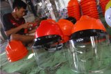 Perajin membuat helm berpelindung wajah (face shield) di rumah produksi CT Helmet, Ngawi, Jawa Timur, Kamis (6/8/2020). Selain berinovasi dengan membuat helm berpelindung wajah bagi tenaga medis, perajin helm setempat juga menggenjot pemasaran melalui pasar daring guna mengatasi penurunan penjualan di masa pandemi COVID-19 yang anjlok hingga 50 persen. Antara Jatim/Ari Bowo Sucipto/zk.