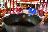 Umat Budha melakukan ibadah sembahyang saat memperingati Dewi Kwan Im mencapai kesempurnaan di Vihara Avalokitesvara, Pamekasan, Jawa Timur, Jumat (7/8/2020). Panitia Pelaksana perayaan Dewi Kwan Im, mengaku  kehadiran umat Budha untuk melaksanakan ibadah di Vihara itu, menurun derastis dibanding perayaan sebelumnya yang mencapai hingga 500 orang, karena Pandemi COVID-19. Antara Jatim/Saiful Bahri/zk