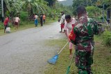 Babinsa bersama warga Kampung Aman Biak Utara karya bakti bersihkan lingkungan