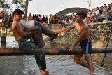 Dua orang taruna Politeknik Perkeretaapian Indonesia (PPI) saling berusaha menjatuhkan dengan memukul menggunakan guling saat Lomba tradisional perang guling di depan kampus PPI di Kota Madiun, Jawa Timur, Minggu (9/8/2020). Lomba tadisional tersebut digelar untuk memeriahkan Hari Ulang Tahun ke-75 Proklamasi Kemerdekaan RI. Antara Jatim/Siswowidodo/zk