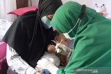 Petugas kesehatan memberikan tetesan vaksin Polio saat berlangsung imunisasi anak di Posyandu Cempaka, Banda Aceh, Aceh, Selasa (11/8/2020). Kementerian Kesehatan dan Ikatan Dokter Indonesia (IDI) menyarankan orang tua untuk tetap mengimunisasi anaknya secara lengkap sesuai dengan usia anak di tengah pandemi COVID-19 guna mencegah berbagai pernyakit dengan menerapkan panduan protokol kesehatan. Antara Aceh/Ampelsa.