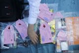 Polisi menunjukkan barang bukti saat ungkap kasus peredaran narkotika di Polrestabes Surabaya, Jawa Timur, Senin (10/8/2020). Satresnarkoba Polrestabes Surabaya menangkap empat tersangka berinisial A A (23), V V (20), J R (23) dan D M (27) atas kasus dugaan mengedarkan narkotika, namun polisi melakukan tindakan tegas terhadap tersangka V E (tewas) yang melawan saat ditangkap. Dalam kasus ini polisi mengamankan sejumlah barang bukti beberapa diantaranya sabu seberat 2 kilogram dan satu senjata api rakitan model 'Revolver'. Antara Jatim/Didik/Zk