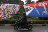 Seorang pengendara motor melintas di depan banner yang dipasang untuk memperingati Hari Ulang Tahun (HUT) Arema di jalan Panglima Sudirman, Malang, Jawa Timur, Selasa (11/8/2020). HUT Arema yang diperingati setiap tanggal 11 Agustus tersebut dilakukan secara sederhana karena adanya larangan konvoi suporter guna pencegahan COVID-19. Antara Jatim/Ari Bowo Sucipto/zk