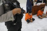 Polisi mempelihatkan tersangka praktik prostitusi online saat rilis ungkap kasus di Polresta Kediri, Jawa Timur, Selasa (11/8/2020). Suami istri berinisial NZ (42) dan KS (40) mengaku telah melakukan praktik prostitusi selama 2 tahun dengan layanan berhubungan badan bertiga dan tukar pasangan yang ditawarkan melalui media sosial. Antara Jatim/Prasetia Fauzani/zk