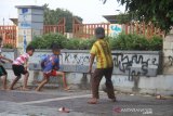 Anak-anak bermain bola di dekat dinding yang penuh coretan di Siring Jalan Jenderal Sudirman Banjarmasin, Kalimantan Selatan, Rabu (12/8/2020). Keberadaan coretan di dinding Siring tersebut merusak keindahan yang menjadi salah satu tempat wisata andalan di Kota Banjarmasin. Foto Antaranews Kalsel/Bayu Pratama S.