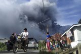 Sejumlah pengendara melintas di Jalan Karo-Langkat dengan latar belakang Gunung Sinabung yang menyemburkan material vulkanik di Desa Kutarayat, Naman Teran, Karo, Sumatera Utara, Kamis (13/8/2020). Pusat Vulkanologi dan Mitigasi Bencana Geologi (PVMBG) menyatakan Gunung Sinabung berstatus level III atau siaga dan meminta masyarakat untuk tidak melakukan aktivitas di desa yang telah direlokasi. ANTARA FOTO/Sastrawan Ginting/nym.