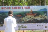 Warga mengamati foto market Masjid Bambu KH Abdul Qodir Hasan di Desa Kiram, Kabupaten Banjar, Kalimantan Selatan, Jumat (14/8/2020). Masjid Bambu yang dapat menampung sekitar 100 orang jamaah dan direncanakan rampung pada akhir Desember tersebut berkonsep seperti salah satu Masjid tertua Kalsel yakni Masjid Sultan Suriansyah dengan ornamen bambu. Foto Antaranews Kalsel/Bayu Pratama S.