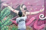 Aktivis mahasiswa seni yang tergabung dalam Komunitas Mural-Marul melukis mural di tembok pinggir jalan raya Kota Tulungagung, Tulungagung, Jawa Timur, Kamis (13/8/2020). Banyaknya waktu luang selama perkuliahan daring dimanfaatkan aktivis mahasiswa seni setempat untuk berekspresi lewat seni mural sambil mengampanyekan penggunaan masker kepada masyarakat selama pandemi COVID-19. Antara Jatim/Destyan Sujarwoko/zk.