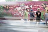 Sejumlah aktivis mahasiswa seni yang tergabung dalam Komunitas Mural-Marul melukis mural di tembok pinggir jalan raya Kota Tulungagung, Tulungagung, Jawa Timur, Kamis (13/8/2020). Banyaknya waktu luang selama perkuliahan daring dimanfaatkan aktivis mahasiswa seni setempat untuk berekspresi lewat seni mural sambil mengampanyekan penggunaan masker kepada masyarakat selama pandemi COVID-19. Antara Jatim/Destyan Sujarwoko/zk.