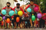 Sejumlah anak adu cepat berlari sambil mengapit balon gas di antara kedua lengan dan kaki dalam sebuah permainan ketangkasan di lingkungan Puri Jepun Permai II, Tulungagung, Jawa Timur, Sabtu (15/8/2020). Lomba adu cepat dan adu tangkas itu digelar warga setempat dalam rangkaian perayaan HUT ke-75 Kemerdekaan RI. Antara Jatim/Destyan Sujarwoko/zk.