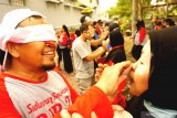 Sejumlah pria adu ketangkasan dan ketrampilan merias pasangannya dengan kondisi mata tertutup masker di lingkungan Puri Jepun Permai II, Tulungagung, Jawa Timur, Sabtu (15/8/2020). Lomba adu cepat dan kekompakan itu digelar warga setempat dalam rangkaian perayaan HUT ke-75 Kemerdekaan RI. Antara Jatim/Destyan Sujarwoko/zk.