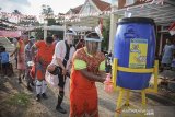 Peserta lomba antre untuk mencuci tangannya sebelum melaksanakan perlombaan sepakbola pria dengan kostum wanita di Cinunuk, Kabupaten Bandung, Jawa Barat, Sabtu (15/8/2020). Panitia perlombaan berinisiatif untuk menerapkan protokol kesehatan di masa pandemi untuk menggelar lomba guna menyemarakan kemerdekaan Indonesia ke 75. ANTARA JABAR/Raisan Al Farisi/agr