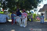 Sejumlah anak mengikuti lomba balap karung di Desa Banjardowo, Kabupaten Jombang, Jawa Timur, Senin (17/8/2020). Berbagai jenis perlombaan seperti balap karung, makan kerupuk tetap digelar masyarakat di tengah pandemi COVID-19, untuk memeriahkan perayaan hari ulang tahun ke-75 Republik Indonesia . Antara Jatim/Syaiful Arif/zk