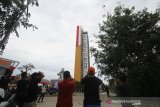 Warga menyaksikan pengibaran bendera merah putih dari gedung tertinggi di Kalimantan Selatan di Aston Banua Hotel dan Convention Center, Kabupaten Banjar, Kalimantan Selatan, Senin (17/8/2020). Manajemen Hotel tersebut berkerjasama dengan TNI dan POLRI mengibarkan bendera merah putih sepanjang kurang lebih 100 meter pada gedung tertinggi yang berada di Kalimantan Selatan untuk memperingati Hari Kemerdekaan ke-75 Republik Indonesia. Foto Antaranews Kalsel/Bayu Pratama S.