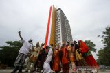 Karyawan hotel menggunakan pakaian adat nasional berfoto bersama dengan latar bendera merah putih dari gedung tertinggi di Kalimantan Selatan di Aston Banua Hotel dan Convention Center, Kabupaten Banjar, Kalimantan Selatan, Senin (17/8/2020). Manajemen Hotel tersebut berkerjasama dengan TNI dan POLRI mengibarkan bendera merah putih sepanjang kurang lebih 100 meter pada gedung tertinggi yang berada di Kalimantan Selatan untuk memperingati Hari Kemerdekaan ke-75 Republik Indonesia. Foto Antaranews Kalsel/Bayu Pratama S.