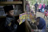 Anak-anak membaca buku di Taman Baca Nafilatul Husna, Banjarwangi, Kabupaten Garut, Jawa Barat, Selasa (18/8/2020). Taman baca yang dibangun di daerah terpencil tersebut ditujukan untuk memfasilitasi dan meningkatkan minat baca anak-anak. ANTARA JABAR/Candra Yanuarsyah/agr
