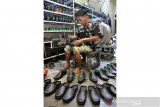 Kadiruddin memperlihatkan produk sepatu buatannya yang dijual Rp100 ribu hingga Rp600 ribu per pasang (tergantung model) di Jalan AR Hakim Lorong Bahagia Medan, Sumatera Utara, Senin (10/8/2020). Produk sepatu yang sudah memiliki hak paten bernama 
