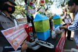 Warga menggunting masker bekas pakai untuk kemudian dibuang dan ditukarkan dengan masker baru pada Bank Masker Polres Blitar Kota yang beroperasi di salah satu pasar tradisional di Blitar, Jawa Timur, Rabu (19/8/2020). Selain bertujuan untuk mengkampanyekan pentingnya menggunakan masker sebagai bagian upaya untuk memutus rantai penyebaran COVID-19, program yang diinisisasi oleh Polres Blitar Kota tersebut juga bertujuan untuk mengkampanyekan cara membuang masker bekas pakai dengan benar. Antara Jatim/Irfan Anshori/zk